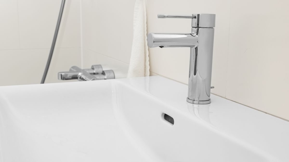 Chrome mixer tap on a white basin in a bathroom
