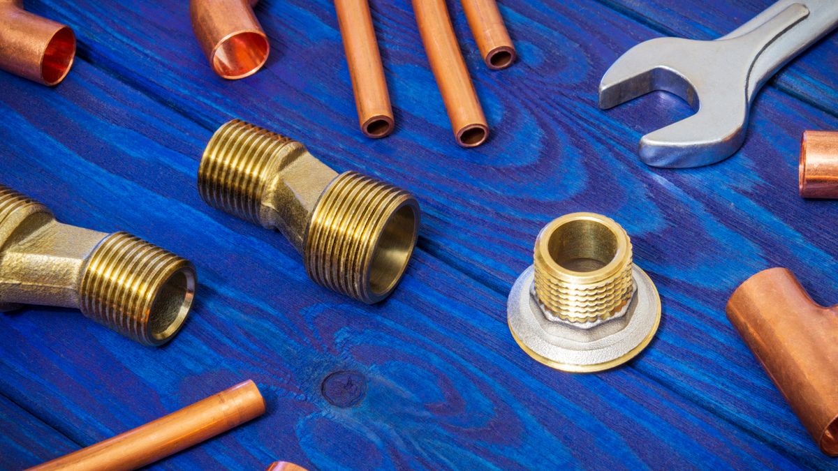 Copper pipe and fittings laid out with a soldering tool
