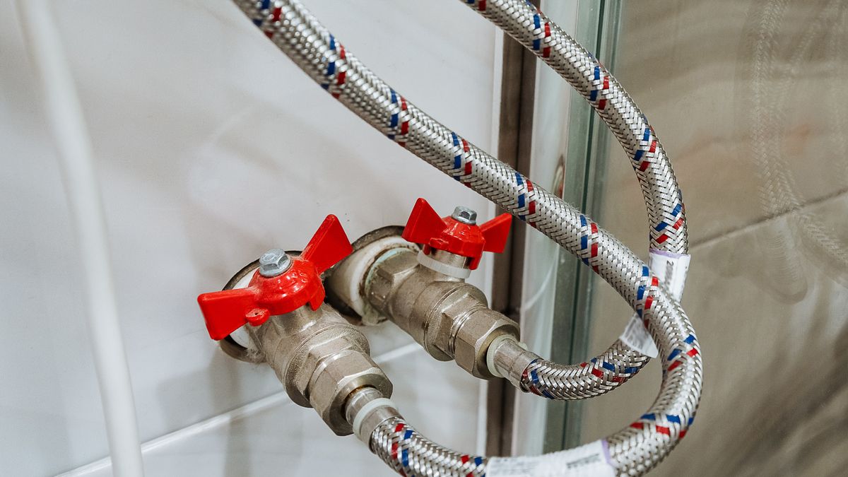 Pair of red-handled shut-off valves feeding braided flexible connectors