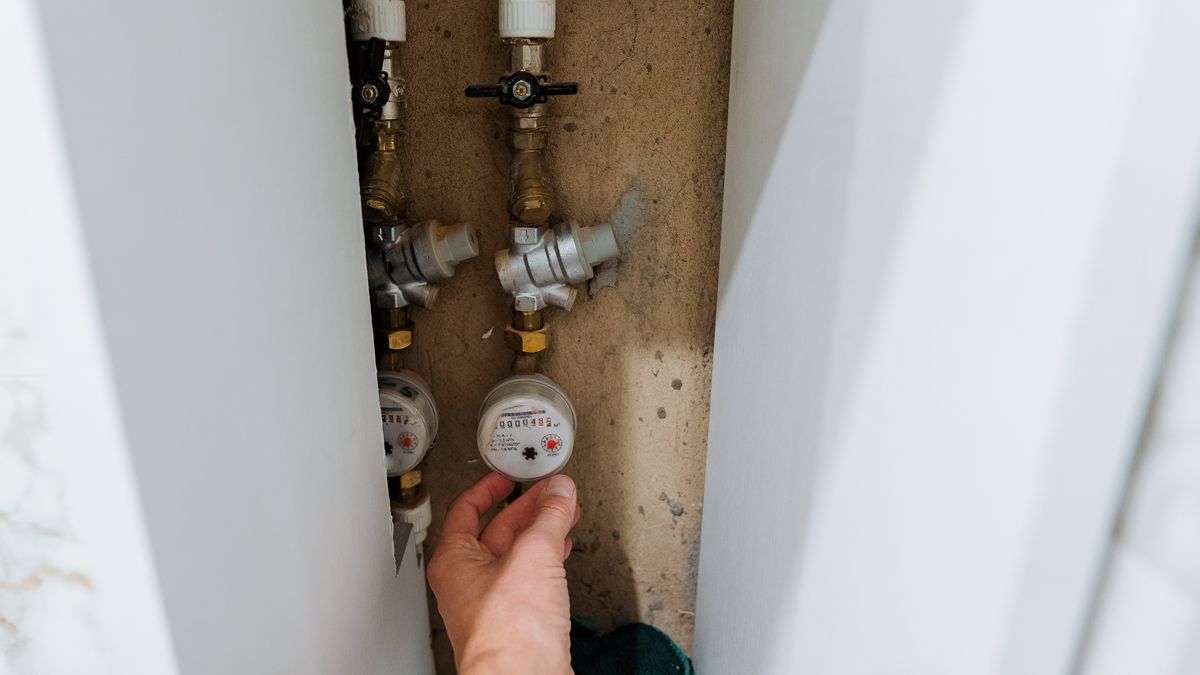 Water meter and isolating valve inside a wall cabinet, being adjusted