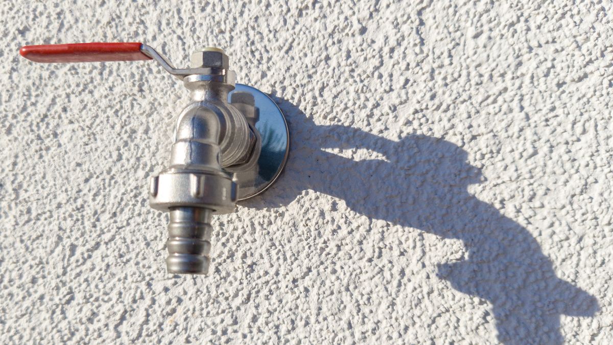 Outside tap mounted on a house wall, the fixture closest to the incoming supply
