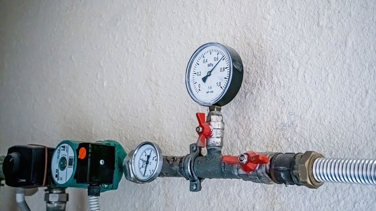 Wall-mounted pipework carrying two pressure gauges side by side